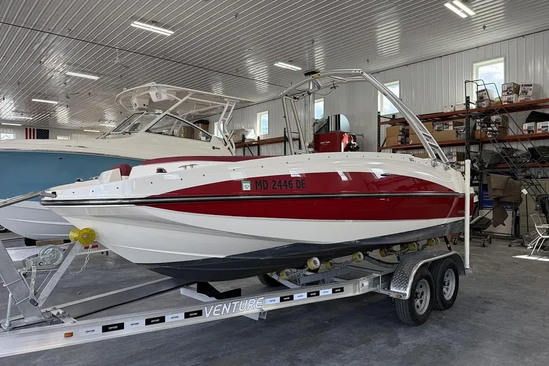Slide: The Image of 2014 Bayliner 190 Deck Boat on trailer in indoor storage facility. - 2