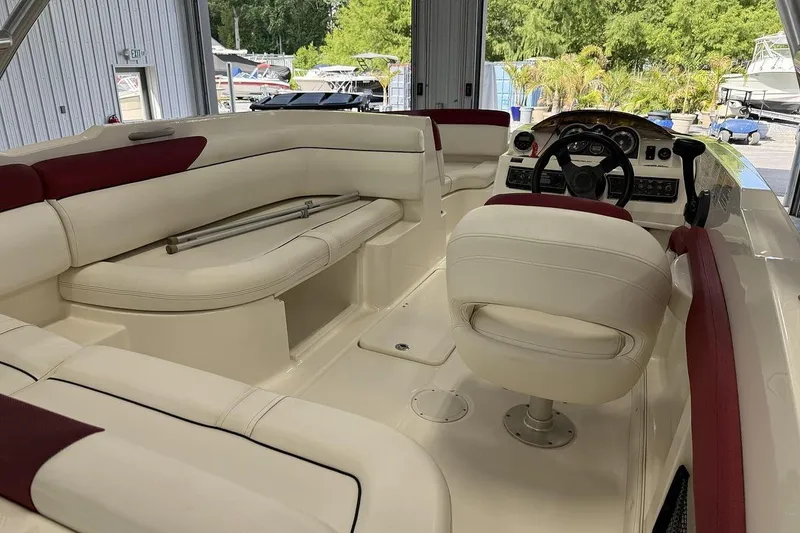 Slide: The Image of 2014 Bayliner 190 Deck Boat interior with white and red seating, steering console. - 4
