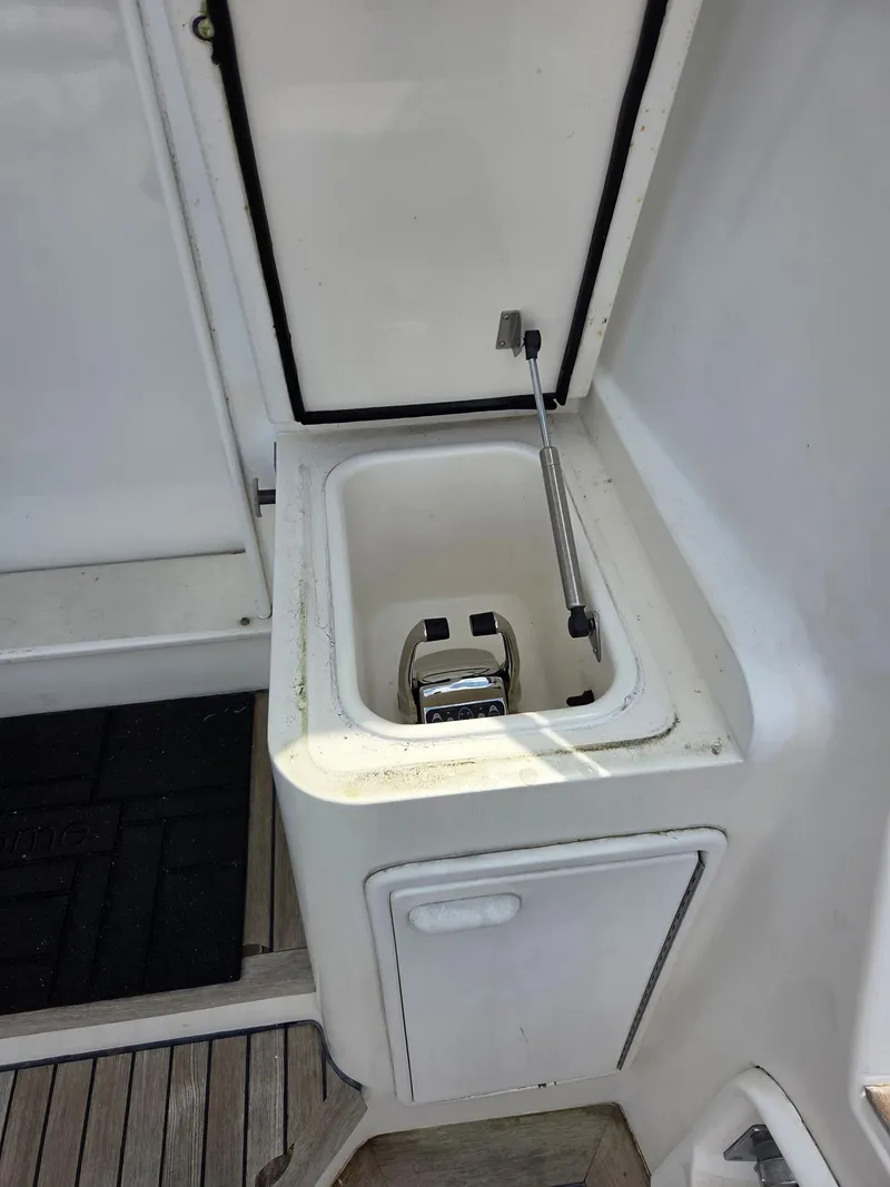 Slide: The Image of An open compartment on a boat with a metal handle and white cover. - 38