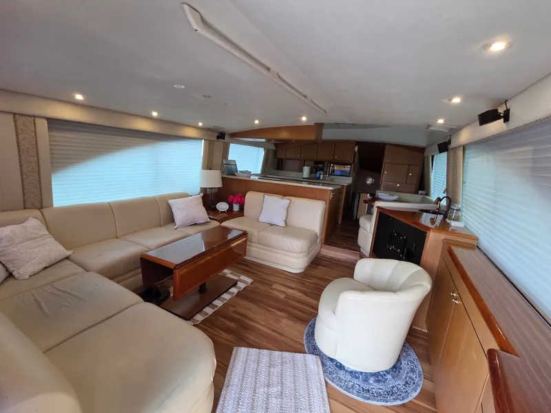 Slide: The Image of Interior of a 2002 Ocean Convertible with beige sofa, wooden table, and kitchen in the background. - 1