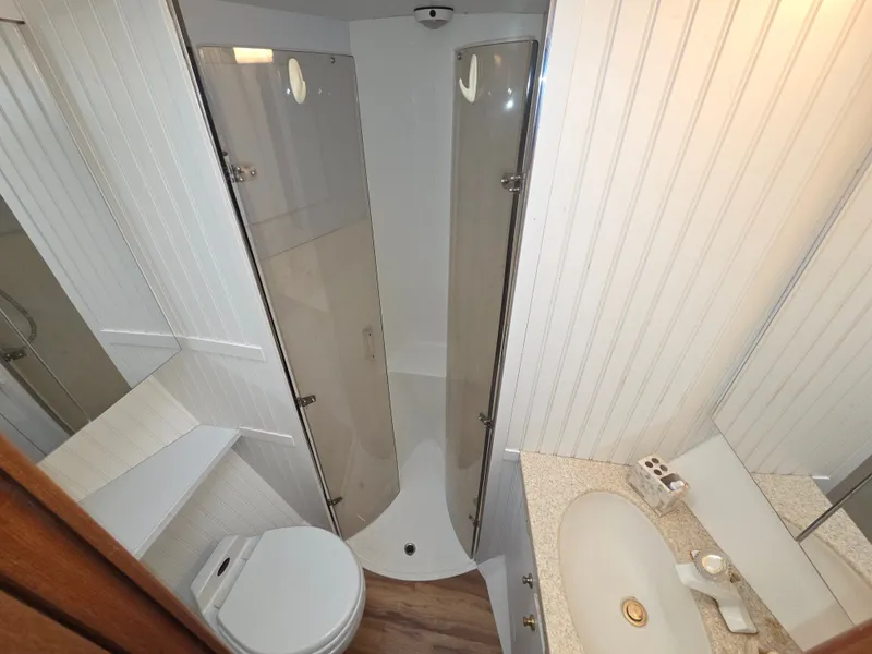 Slide: The Image of The image shows a boat bathroom with a shower, sink, and toilet. - 17