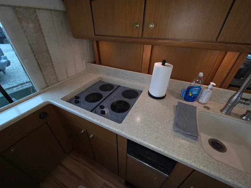 Slide: The Image of The kitchen of a 2002 Ocean Convertible with a stove, sink, and countertop. - 14