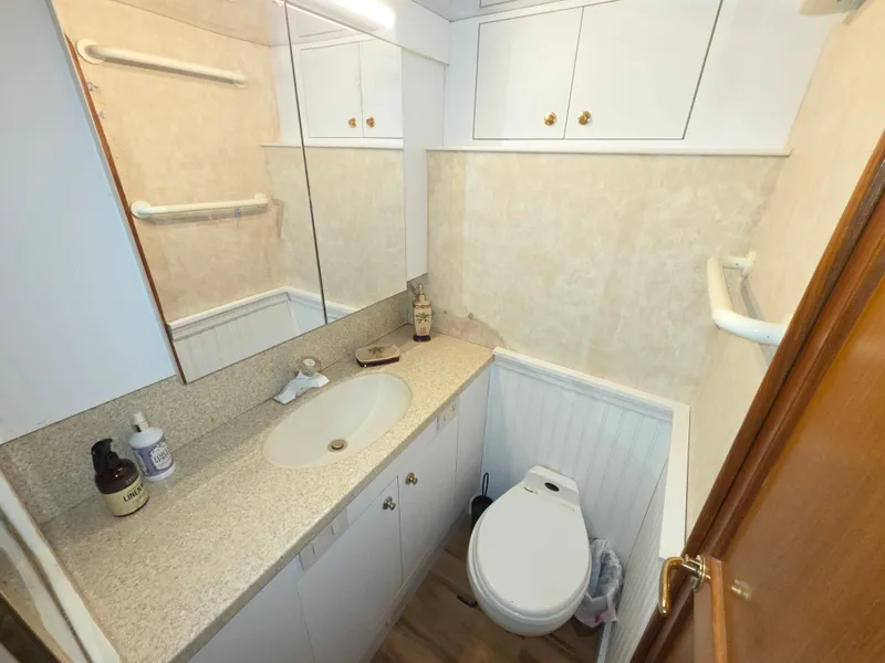 Slide: The Image of The image shows a boat bathroom with a sink, toilet, and storage cabinets. - 21