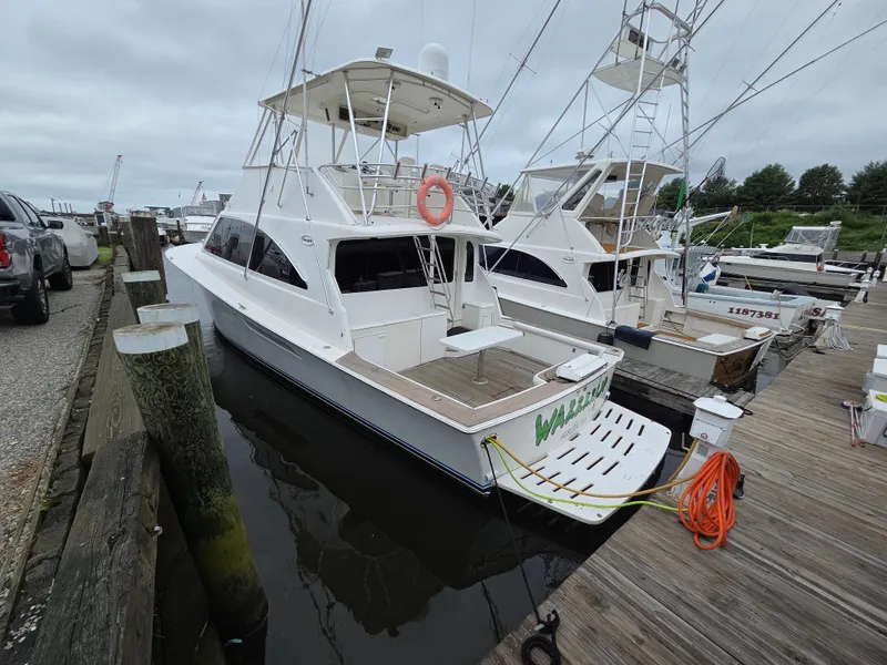 Slide: The Image of A white boat docked, featuring an elevated helm and ladder, with a spacious deck area. - 27
