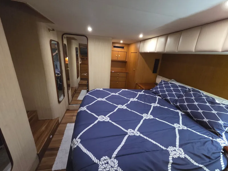 Slide: The Image of The image shows a cozy bedroom on a boat with a large bed and wooden furnishings. - 9