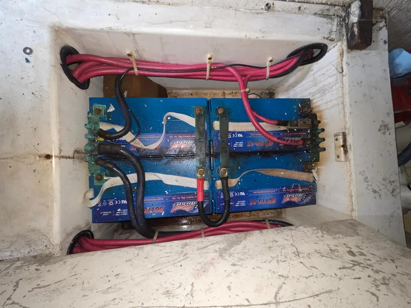 Slide: The Image of Batteries in a boat with red and black cables, mounted in a white compartment. - 24