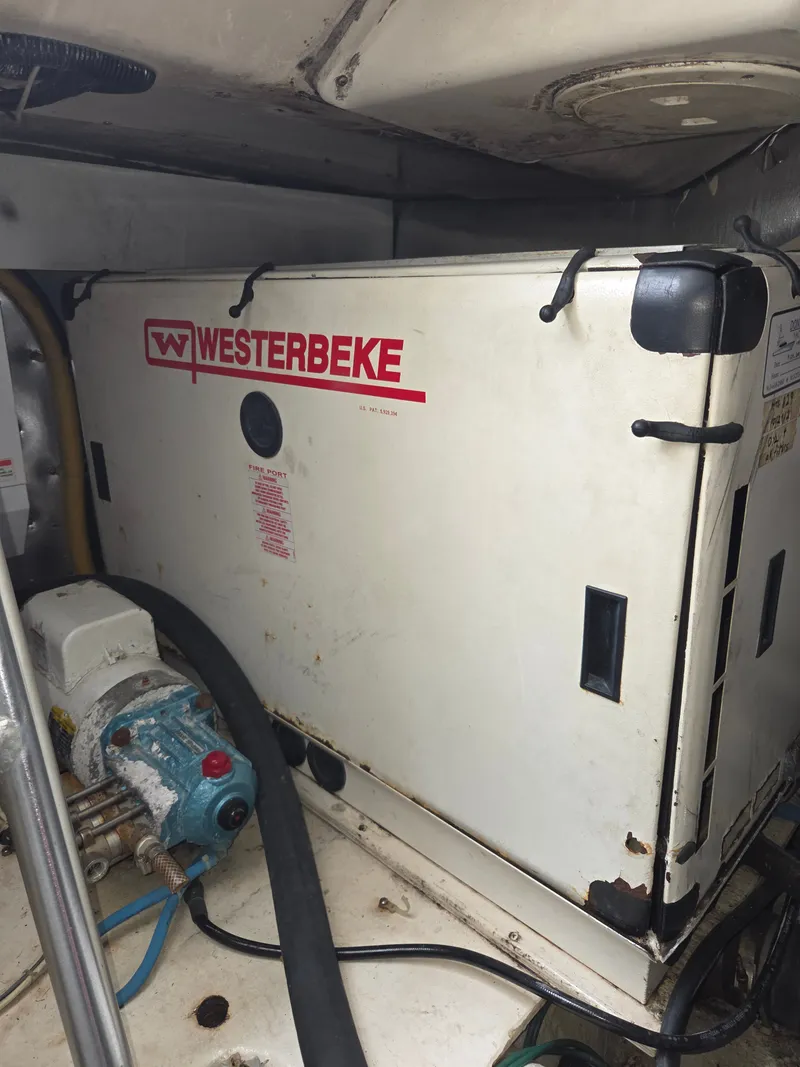 Slide: The Image of A Westerbeke generator in an engine room, surrounded by hoses and pipes. - 35