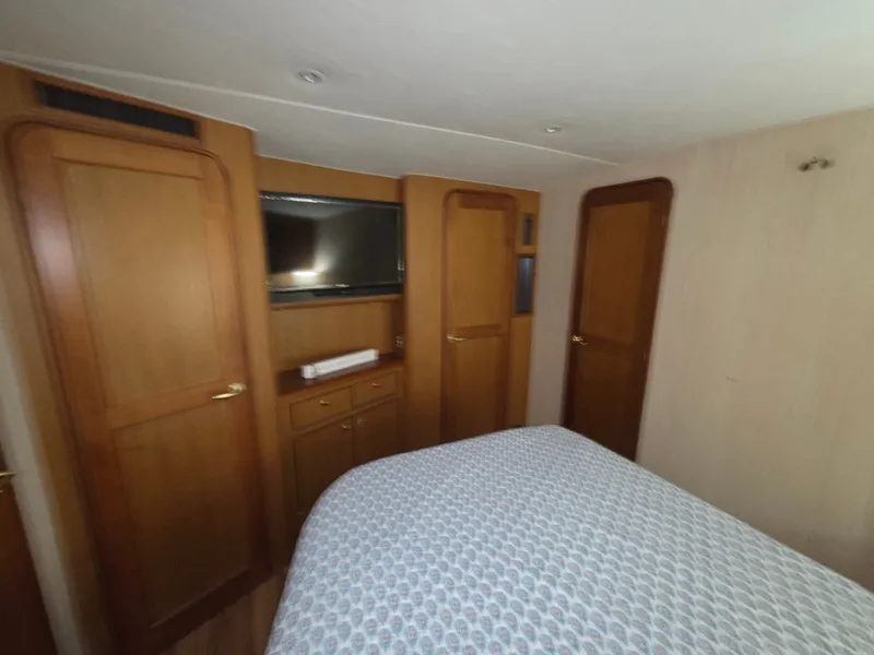 Slide: The Image of The image shows a cozy cabin with a double bed, wooden furniture, and a built-in TV. - 19