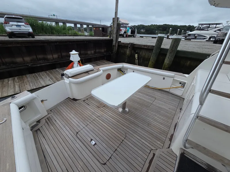 Slide: The Image of The image shows the aft deck of a 2002 Ocean Convertible. It features a table and seating. - 29
