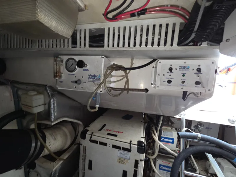 Slide: The Image of The engine room of a 2002 Ocean Convertible with various equipment and hoses. - 23