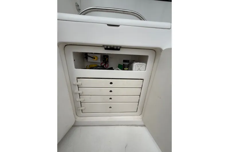 Slide: The Image of A white cabinet with four drawers and an open compartment containing wires and accessories. - 30