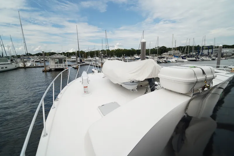 Slide: The Image of 2005 Post 50 Convertible yacht docked at a marina under a partly cloudy sky. - 6