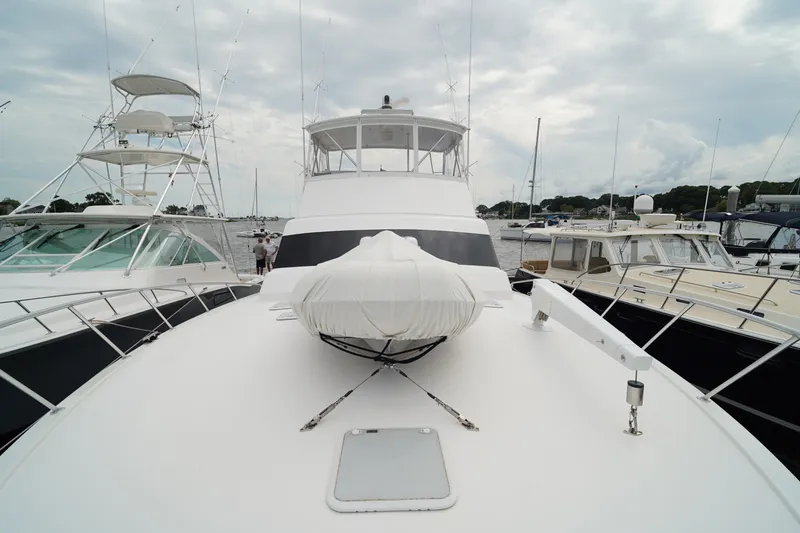 Slide: The Image of 2005 Post 50 Convertible yacht docked at marina, surrounded by other boats under cloudy sky. - 5