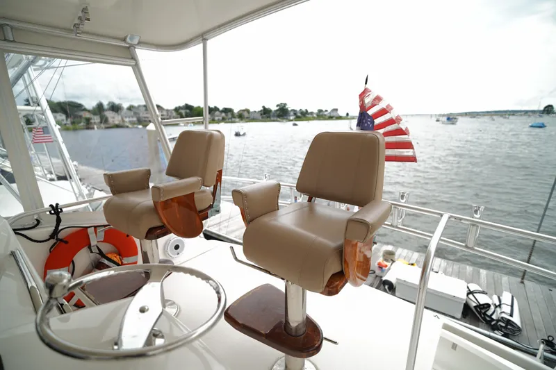 Slide: The Image of Luxury yacht deck with captain's chairs, American flag, and scenic waterfront view. - 12
