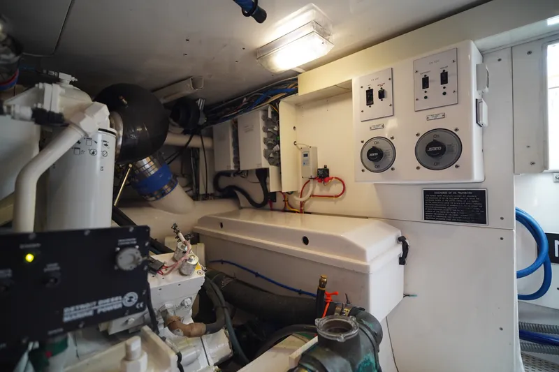 Slide: The Image of Engine room of a 2005 Post 50 Convertible yacht, featuring control panels and machinery. - 25