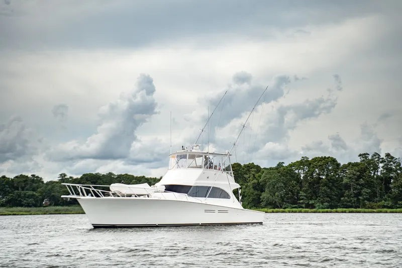 Slide: The Image of Luxury 2005 Post 50 Convertible yacht on a serene waterway with cloudy skies. - 1