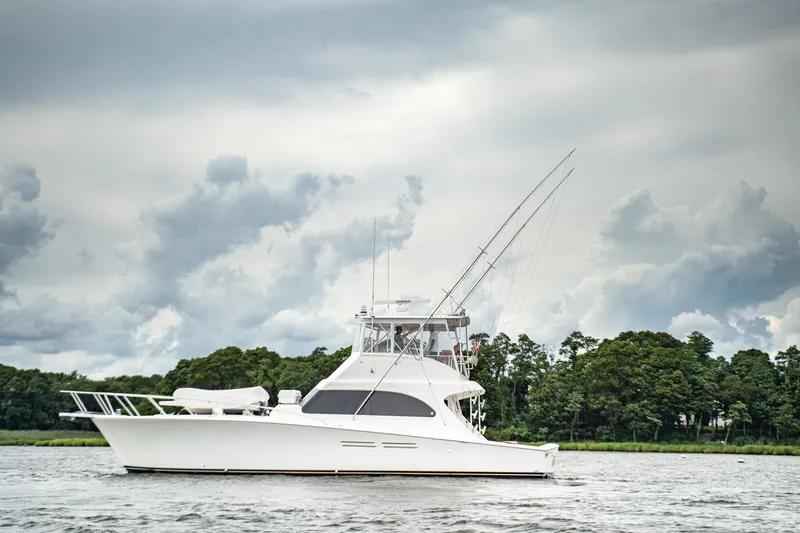 The Image of 2005 Post 50 Convertible yacht cruising on a calm river under a cloudy sky. - 0