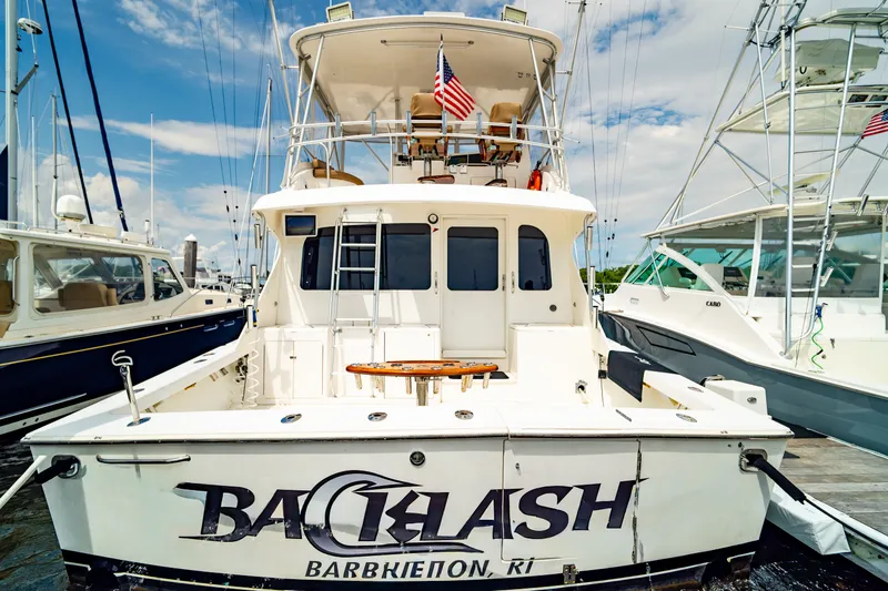 Slide: The Image of 2005 Post 50 Convertible yacht docked, featuring "Backlash" name and American flag. - 7