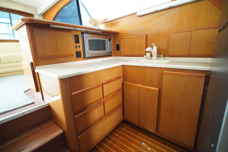 Slide: The Image of Luxurious 2005 Post 50 Convertible yacht kitchen with wood cabinetry and modern appliances. - 18