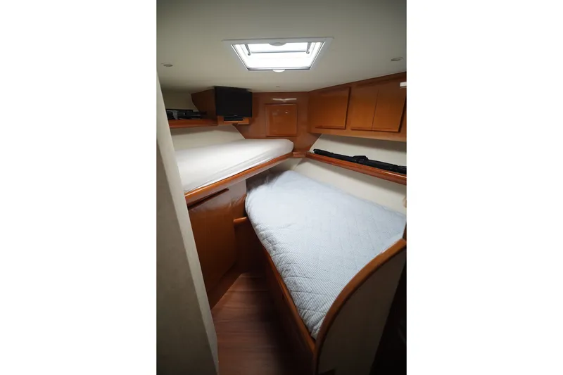 Slide: The Image of Interior cabin of a 2005 Post 50 Convertible yacht with wooden cabinetry and bedding. - 23
