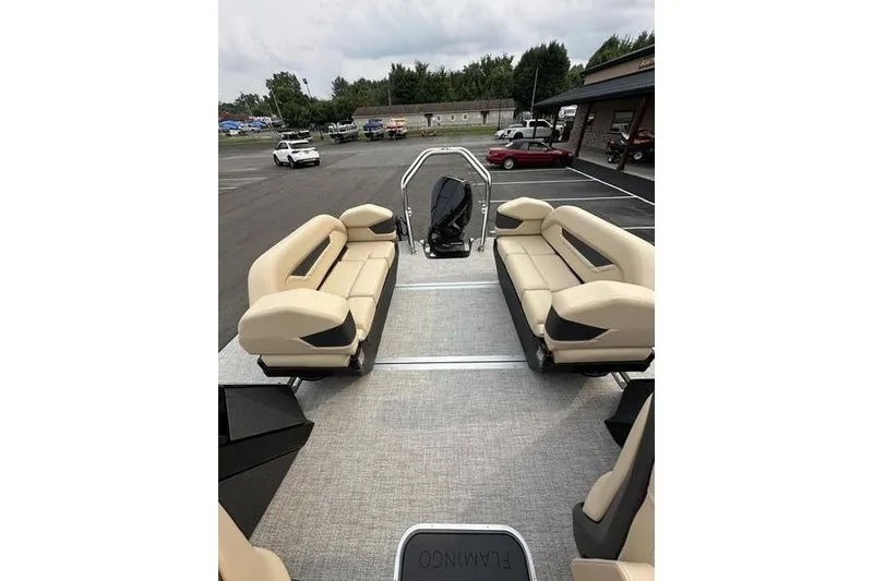 Slide: The Image of 2026 Flamingo Rove 24' boat interior with beige seating in a parking lot. - 35