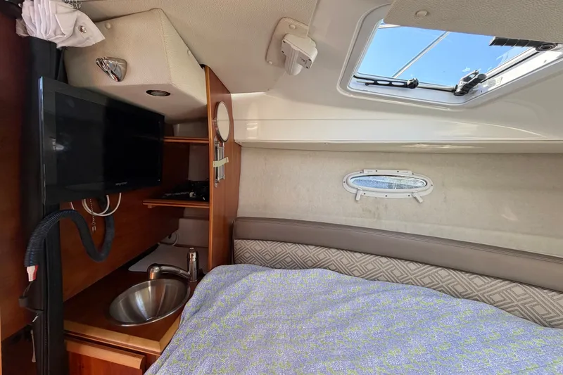 Slide: The Image of 2017 Cutwater C-242 Coupe interior with bed, sink, and TV under skylight. - 22