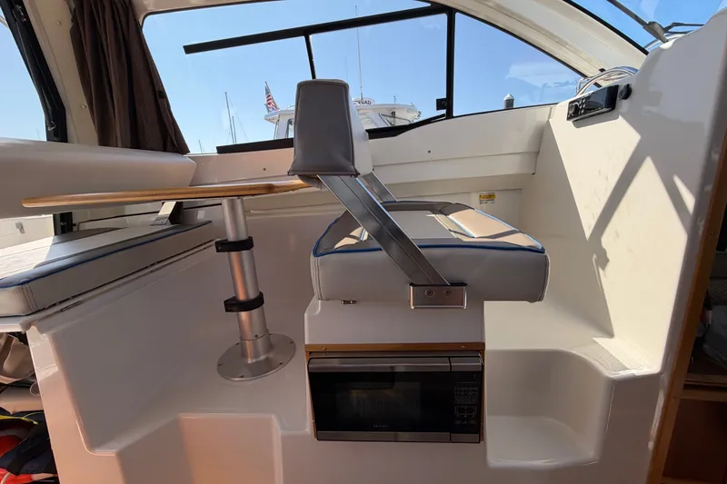 Slide: The Image of Interior of a 2017 Cutwater C-242 Coupe boat featuring seating and a compact table. - 11