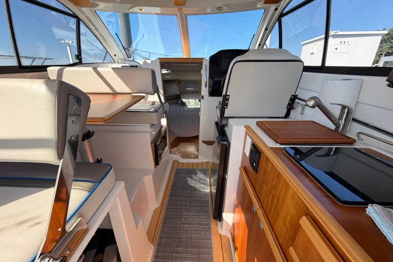 Slide: The Image of Interior of 2017 Cutwater C-242 Coupe boat, featuring seating, table, and kitchenette. - 9