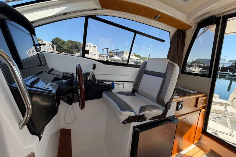 Slide: The Image of Interior of a 2017 Cutwater C-242 Coupe boat with helm and seating area. - 12
