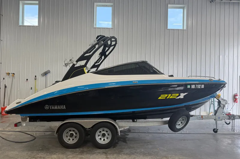 The Image of 2022 Yamaha Boats 212XD on trailer in indoor storage facility. - 0