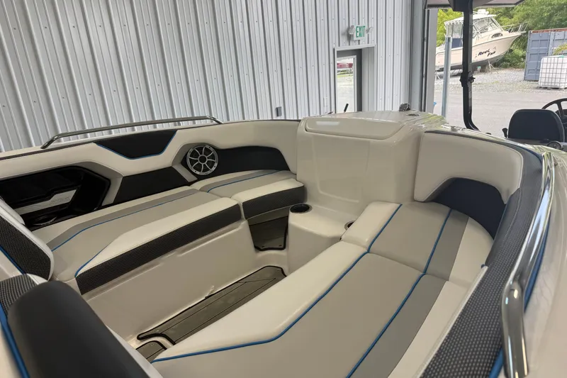 Slide: The Image of 2022 Yamaha Boats 212XD interior with sleek seating and modern design in a showroom. - 5