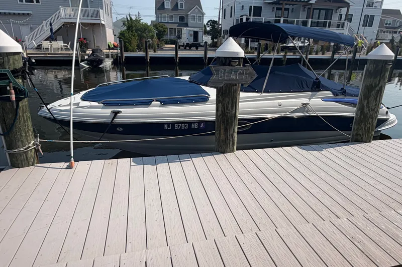 Slide: The Image of 2008 Crownline 240 LS boat docked at a marina with blue covers. - 1