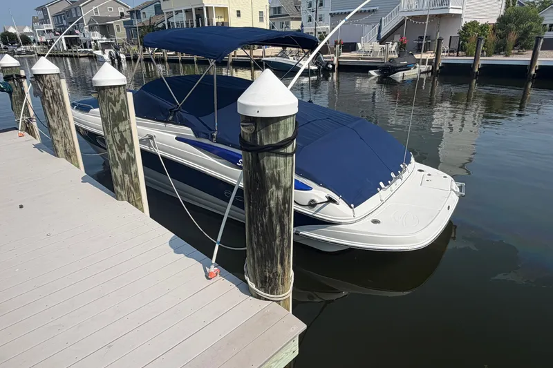 Slide: The Image of 2008 Crownline 240 LS boat docked with blue cover in a marina setting. - 4