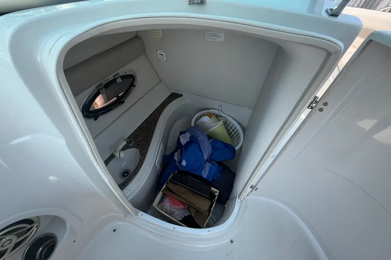 Slide: The Image of Interior storage compartment of a 2008 Crownline 240 LS boat with various items. - 21