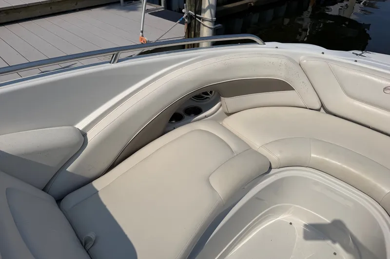 Slide: The Image of 2008 Crownline 240 LS boat interior with white cushioned seating and cup holders. - 13