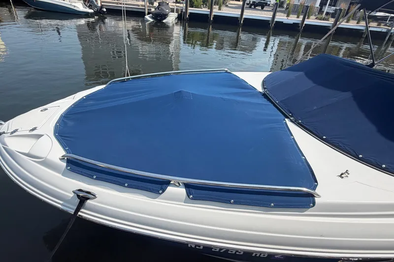 Slide: The Image of 2008 Crownline 240 LS boat with blue cover docked at marina. - 2