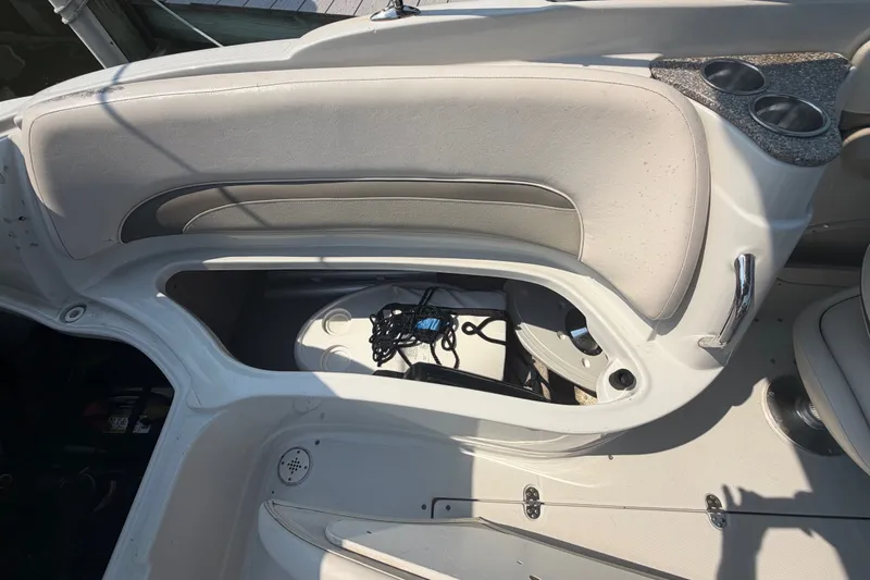 Slide: The Image of 2008 Crownline 240 LS boat interior with open storage compartment and cup holders. - 17