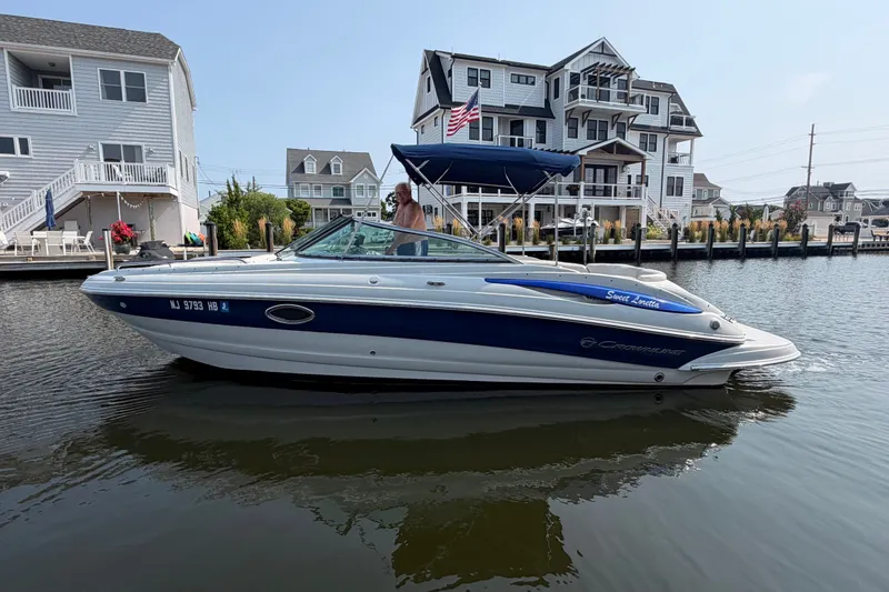 The Image of 2008 Crownline 240 LS boat on water near waterfront homes. - 0