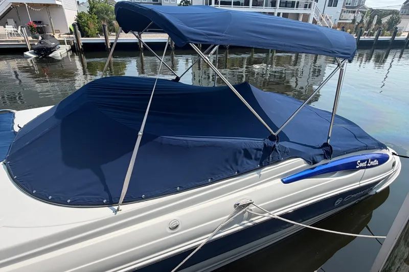 Slide: The Image of 2008 Crownline 240 LS boat with blue cover docked by waterfront homes. - 3