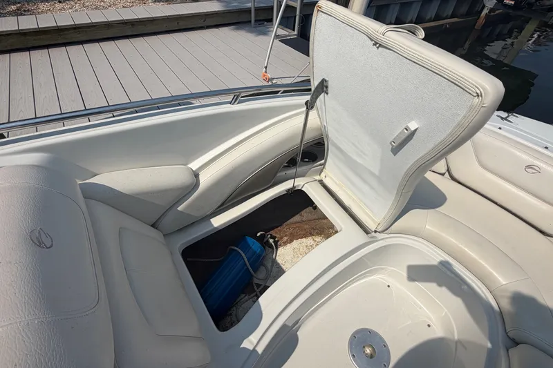 Slide: The Image of 2008 Crownline 240 LS boat interior with open storage compartment, dockside view. - 10