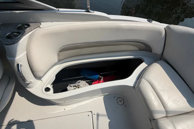 Slide: The Image of 2008 Crownline 240 LS boat interior with open storage compartment and cup holders. - 16
