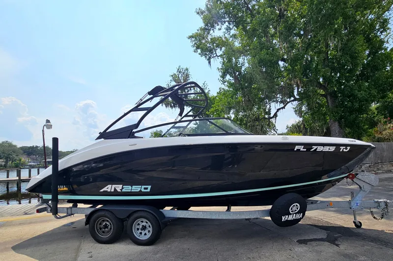Slide: The Image of 2023 Yamaha Boats AR250 on trailer, parked near a scenic waterfront. - 3