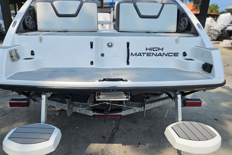 Slide: The Image of 2023 Yamaha Boats AR250 rear view with "High Maintenance" text, featuring swim platform and seating. - 31