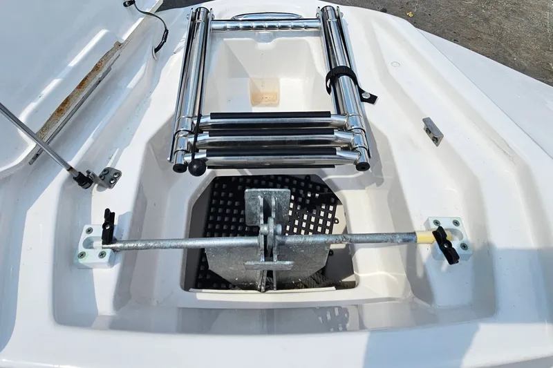 Slide: The Image of 2023 Yamaha Boats AR250 anchor compartment with ladder, showcasing storage and functionality. - 12