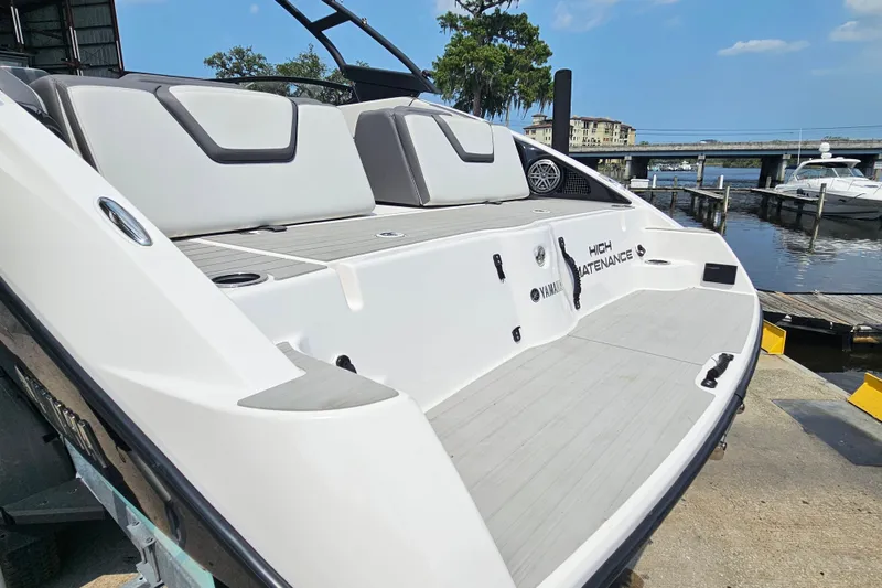 Slide: The Image of 2023 Yamaha Boats AR250 at dock, showcasing sleek design and spacious seating area. - 7