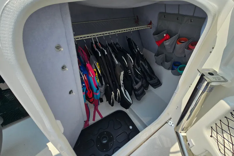 Slide: The Image of Storage compartment in 2023 Yamaha AR250 boat with life jackets and accessories. - 18