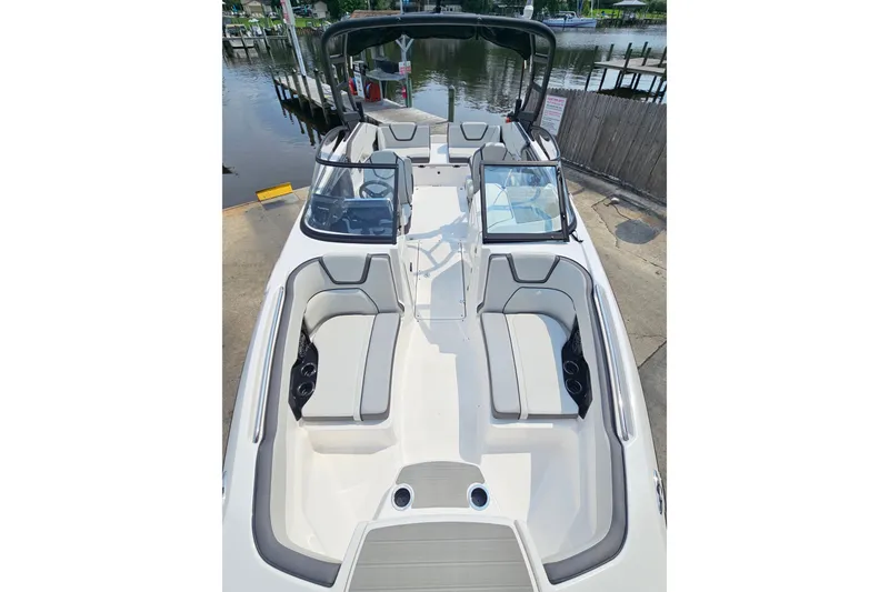 Slide: The Image of 2023 Yamaha Boats AR250 interior with sleek seating and modern design at a dock. - 13