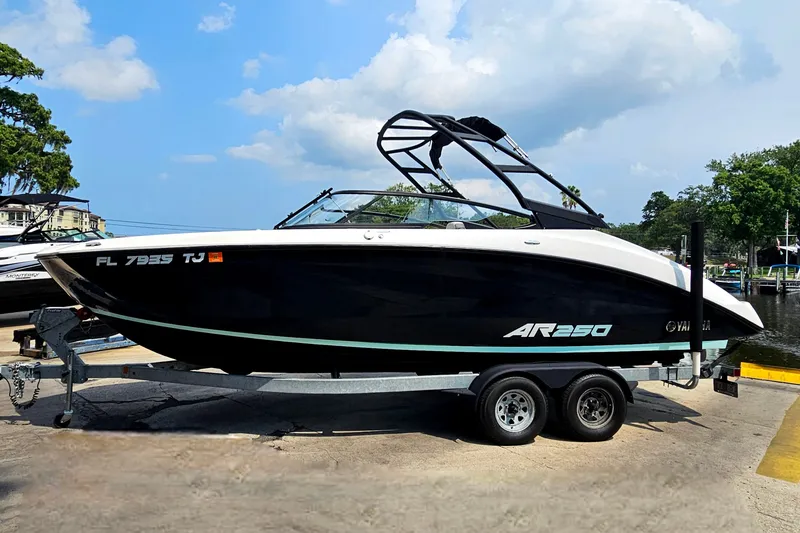 Slide: The Image of 2023 Yamaha AR250 boat on trailer, sleek black design, parked outdoors. - 1