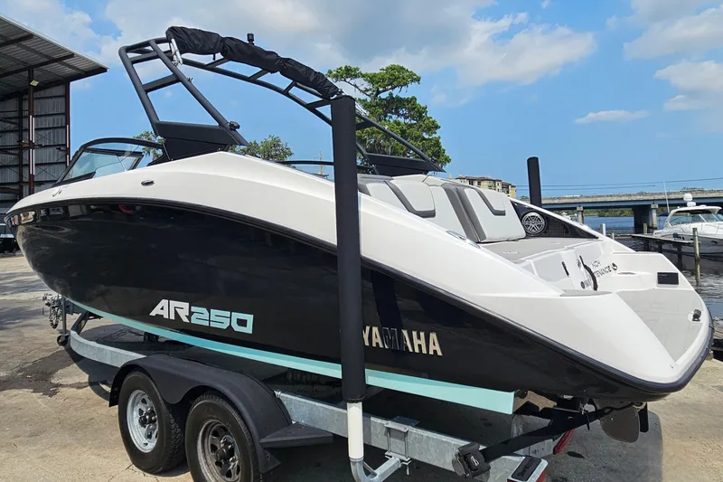 Slide: The Image of 2023 Yamaha Boats AR250 on trailer, dockside with clear sky background. - 6