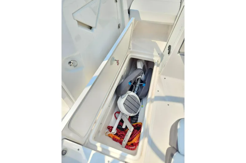 Slide: The Image of 2023 Yamaha AR250 boat storage compartment with life jackets and ropes. - 30